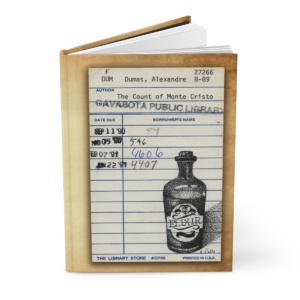 Heid Pitre writing journal with an old library borrowers card on the cover of Dumas' Count of Monte Cristo for book lovers and librarians.